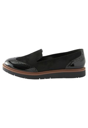 Zwarte instap schoenen met een mix van lak- en suède texturen, voorzien van brogue details op de neus en een dikke zwarte zool met een bruine accent.