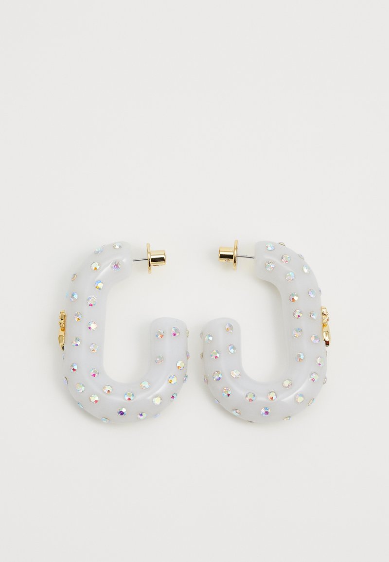 Orecchini a cerchio traslucidi bianchi a forma di "C", decorati con strass iridescenti e accessori di colore oro.