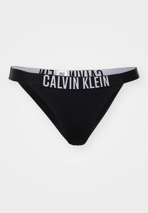 Zwarte stringonderbroek met een brede elastische tailleband voorzien van witte "CALVIN KLEIN" letters. Gladde stof met minimale stikseldetails.