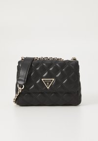 Borsa a tracolla nera in pelle ecologica trapuntata con tracolla a catena diagonale, dotata di un logo in metallo dorato triangolare sul davanti. Forma rettangolare compatta.