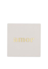 Fyrkantig, ljusrosa objekt med en slät yta. Har ordet "amor" i guldtryck, centrerat och upphöjt. Enkel kantdesign.
