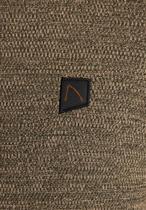 Gebreide stof in aardetinten met een gestructureerd patroon. Bevat een zwarte patch met een oranje driehoekig ontwerp. Ronde randen en naadloze afwerking.
