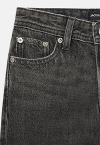 Sorte denim jeans med et klassisk femlomme design, sølvfargede detaljer og synlig søm, med en litt falmet tekstur.