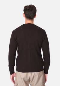 Maglione marrone in maglia costina con maniche lunghe e scollo rotondo, caratterizzato da un motivo testurizzato e un design a tinta unita.
