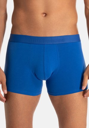 Siniset puuvillaiset bokserishortsit, joissa on sileä pinta ja pehmeä joustava vyötärönauha, jossa kohopainettu brändi. Keskipitkät, reisien puoliväliin ulottuvat mallit.