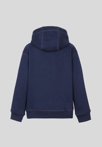 Un hoodie bleu marine en tissu doux avec une coupe décontractée, une grande capuche et des coutures contrastées le long des coutures. Pas de poches avant visibles.