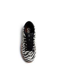 Sneaker a strisce zebrate in bianco e nero con lacci neri, punta arrotondata e suola in gomma marrone. Logo visibile sulla linguetta.