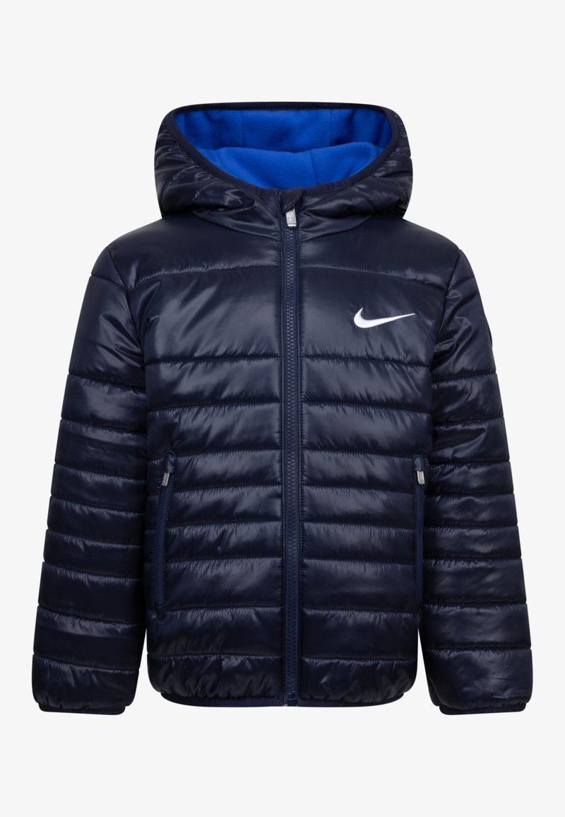 Ναυτικό μπουφάν με παντελόνι, διαθέτει κουκούλα, με μπλε αντίθεση στο εσωτερικό, μπροστινό φερμουάρ και πλαϊνές τσέπες. Περιλαμβάνει το λογότυπο της Nike σε λευκό χρώμα στο στήθος.