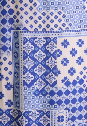 Textília s rôznymi modrými vzormi, vrátane kvetinových a geometrických dizajnov, na svetlom pozadí. Hladká textúra, látka strednej hmotnosti.