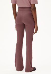 Flared, high-waisted pants in a muted mauve color, made from soft, stretchy fabric. Features a seamless waistband and smooth texture.