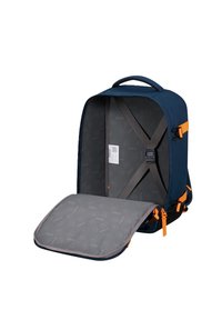 Valigia aperta di colore blu navy con interno grigio, cinghie incrociate regolabili e zip e fibbie laterali arancioni.