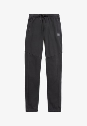 Mustat urheiluhousut, jotka on valmistettu pehmeästä ja joustavasta kankaasta. Ominaisuuksiin kuuluvat elastinen vyötärönyöri, sivutaskut ja kapenevat lahkeet.