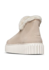 Beige suède enkellaars met fluffy crèmekleurige voering en dikke witte ribbelzool, met een gladde textuur en minimale naaddetails.
