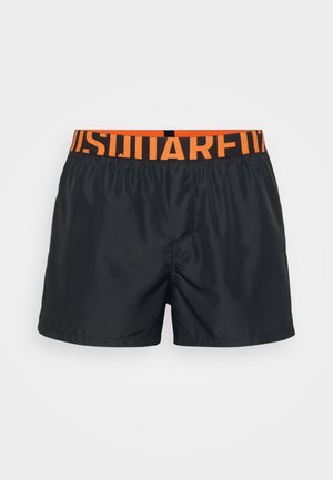 Bañadores de natación para hombres negros con una cinturilla elástica naranja que presenta un texto negro en negrita, mostrados sobre un fondo blanco.