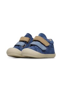 Blauwe leren kinderschoenen met beige klittenbandsluitingen, ronde neuzen, gestructureerde rubberen zolen en een klein reliëfdetail aan de zijkant.