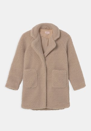 Manteau teddy beige à manches longues avec large col, deux poches plaquées devant et tissu doux texturé.