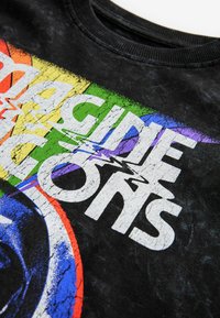 Schwarzes T-Shirt mit einem grafischen Design, das mehrfarbige Streifen und fettgedruckten weißen Text "Imagine Icons" in einem vintage Look zeigt.