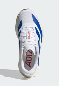 Baskets de sport blanches et bleues avec "ADIZERO" en rouge sur la languette et la semelle intérieure, vues de dessus sur une surface blanche.