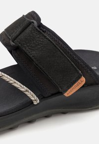 Mustad sandaalid nahk- ja elastne rihmadega, millel on tekstuuriga jalatugi ja hall dekoratiivne köieelement. Includes brändi nahkdetail.