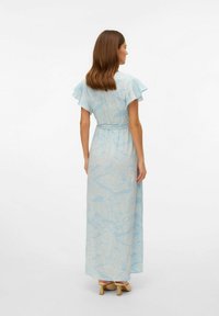 Maxi obleka v svetlo modri barvi s cvetličnim vzorcem, kratkimi nabranimi rokavi, zategnjenim pasom in lahkotnim materialom. Ima mehak otip in dolžino do gležnjev.