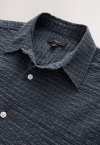 Camicia a quadri blu scuro con trama, colletto, bottoni bianchi e etichetta con taglia M del marchio NEXT.