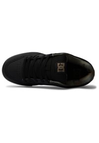 Black sneaker with textured upper, round toe, and flat laces. Interior features a camouflage pattern. Includes logo on tongue and padded collar.