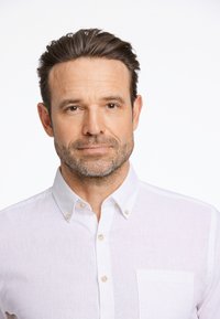 Camicia bianca con bottoni a collo classico e piccolo taschino sul petto, realizzata in tessuto leggero, con colletto arrotondato e bottoni a contrasto.