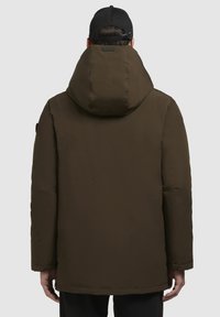 Brun polstret frakke med hætte, der har en glat tekstur og et minimalistisk design. Har et synligt mærke og en enkel silhuet.