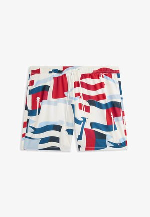 Bañador corto de hombre con cintura elástica y cordón, con un patrón abstracto de bandera en rojo, blanco y azul sobre fondo blanco.