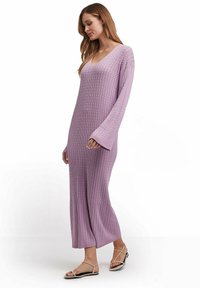 Langes, locker sitzendes Kleid aus leichtem Lavendelstrickmaterial mit V-Ausschnitt, gerippter Textur und Glockenärmeln.