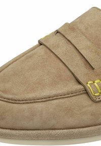 Mocassin en daim marron clair avec bride et détail de surpiqûres jaunes sur le côté, mettant en valeur une texture douce et un design épuré.