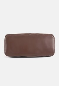 Bolsa rectangular de cuero marrón con superficie lisa y bordes cosidos, vista desde abajo sobre un fondo liso.