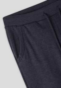 Pantaloni della tuta grigio scuro con vita a coste, tasche laterali e un tessuto morbido e testurizzato, angolati per una migliore visibilità.