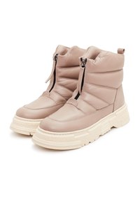 Botas de tobillo de cuero beige con textura acolchada, que presentan una cremallera lateral y una suela blanca gruesa. Diseño de punta redondeada y cuello acolchado.