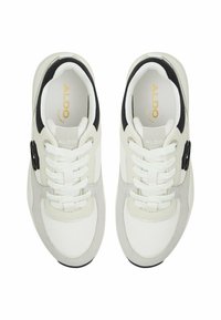 Sneaker sportive bianche e grigie con una texture liscia, dotate di accenti neri, chiusura con lacci e un logo sulla linguetta.