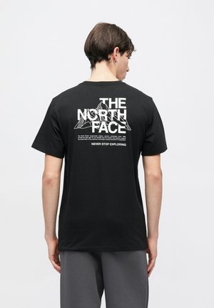 Czarny bawełniany T-shirt z dużym białym nadrukiem na plecach zawierającym nazwę marki "THE NORTH FACE" oraz elementy górskiego wzoru. Krótkie rękawy.