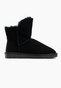 Botas de ante negras hasta el tobillo con un suave forro de piel, que presentan un borde superior curvado y una suela de goma texturizada. Diseño abierto cerca del tobillo.