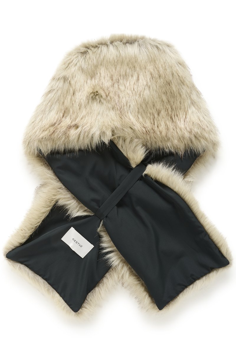 Sciarpa in pelliccia sintetica beige con fodera interna nera, che mostra un'etichetta bianca con il testo "GESTUZ".