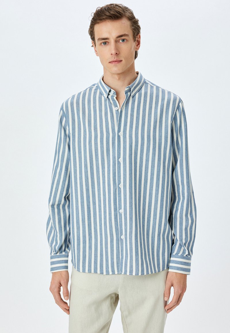 Blauw-wit gestreepte overhemd met lange mouwen en een knoopsluiting kraag; heeft verticale strepen en een relaxte pasvorm.