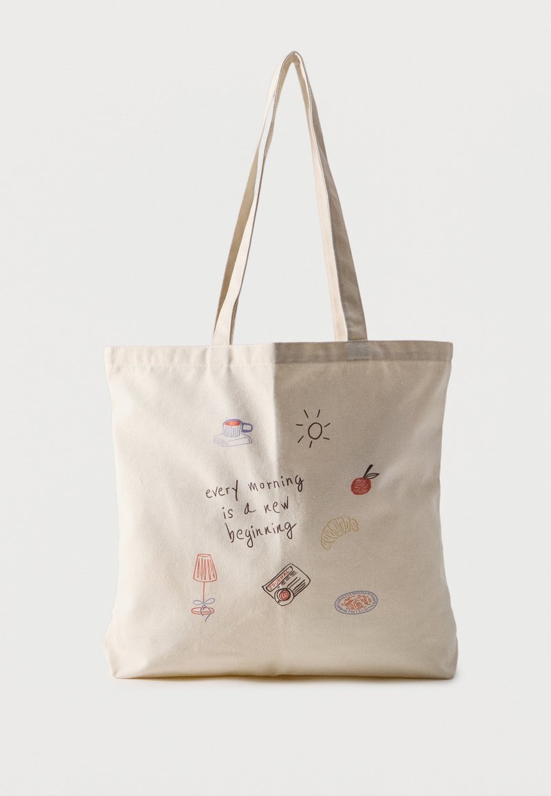 Sac cabas beige avec de longues anses, décoré de petites illustrations et du texte "chaque matin est un nouveau départ."