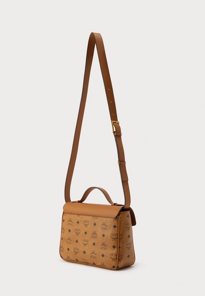 Sac bandoulière en cuir marron clair avec motif logo, forme structurée, poignée supérieure et sangle ajustable. Texture lisse avec des accents de quincaillerie ton or.