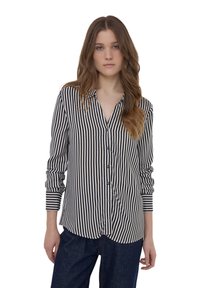 Camicia a righe bianche e nere con una vestibilità comoda, maniche lunghe e polsini arrotolabili. Tessuto liscio con design del colletto.