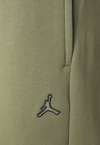 Olivgröna joggingbyxor tillverkade av en mjuk bomullsmix med en slät yta. Har en svart broderad Jumpman-logga på sidan.