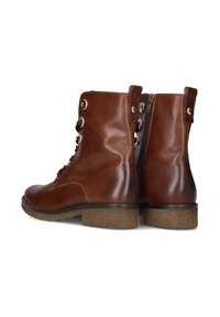 Bruine leren enkelboots met zijrits, vetersluiting aan de voorkant met metalen oogjes en gestructureerde lage rubberen hakken.