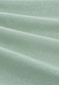 Texturovaná látka v jemné mátové zelené s jemným vertikálním žebrováním a subtilním leskem. Hladký povrch s od reflective qualities.