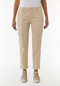 Beige cargobroek met een tapered fit. Beschikt over cargopockets aan de zijkanten, een sluiting met een knoop aan de voorkant en een gladde, duurzame stof.
