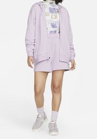 Světle levandulová krátká mikina s kapucí, odpovídající šortky a vzorovaný top. Měkká látka, elastický pas, vrstvený vzhled, spolu se světle šedými teniskami.