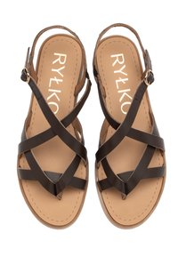 Brązowe skórzane sandały z krzyżującymi się paskami, regulowanym zapięciem i beżową wkładką. Płaska podeszwa z detalami szewnymi. Marka oznaczona na wkładce.