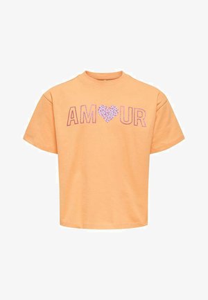 T-shirt à manches courtes couleur pêche avec le mot « AMOUR » sur la poitrine, avec un cœur à motif léopard remplaçant la lettre « O ».