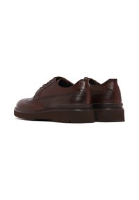 Chaussures en cuir brun foncé pour hommes avec un design brogue à bout ailé, détails perforés et semelles en caoutchouc épais, vues de l'arrière et de côté.